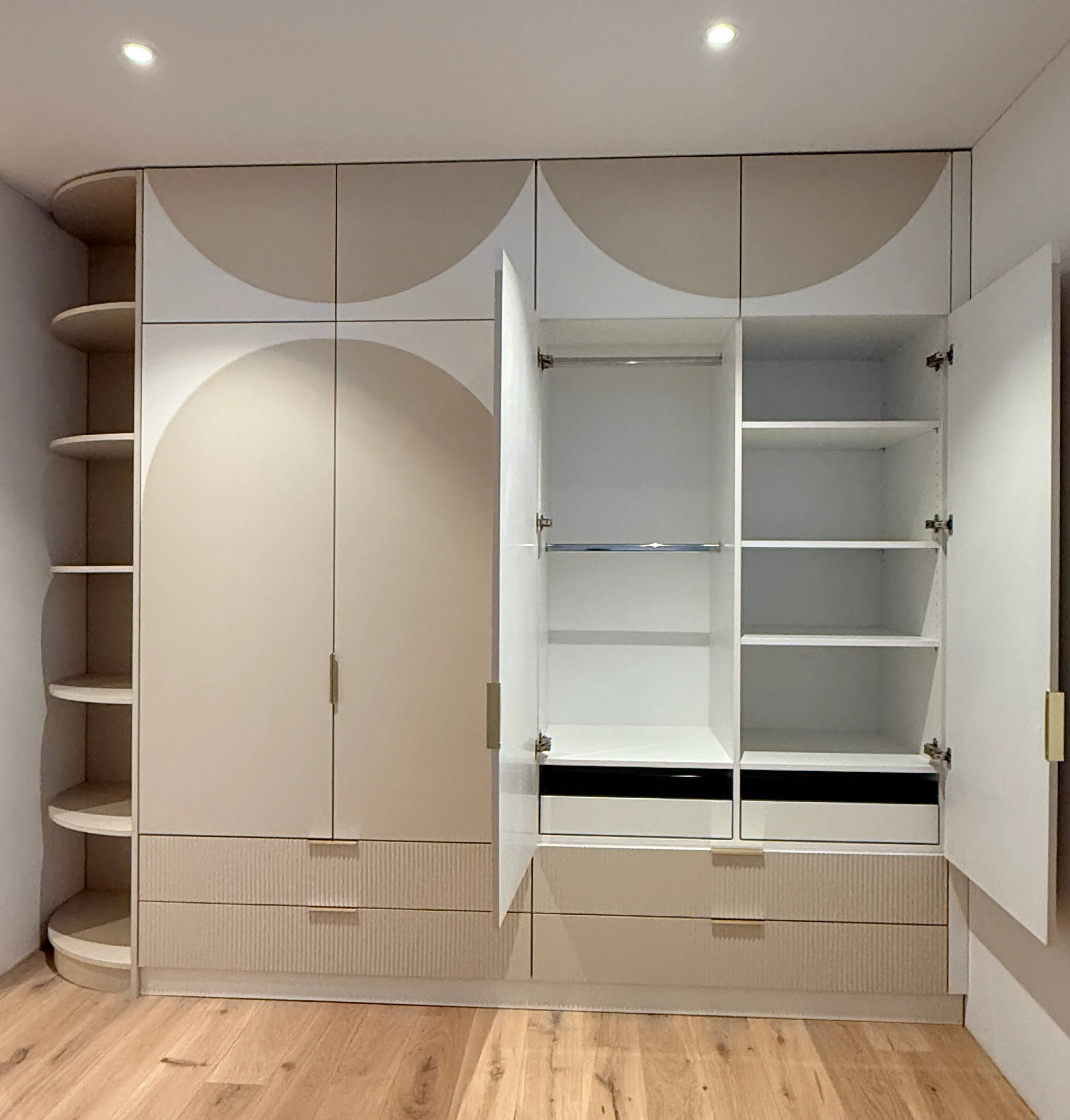 Moderner Einbauschrank nach Maß mit runden Designelementen, offenen Regalen und integriertem Stauraum