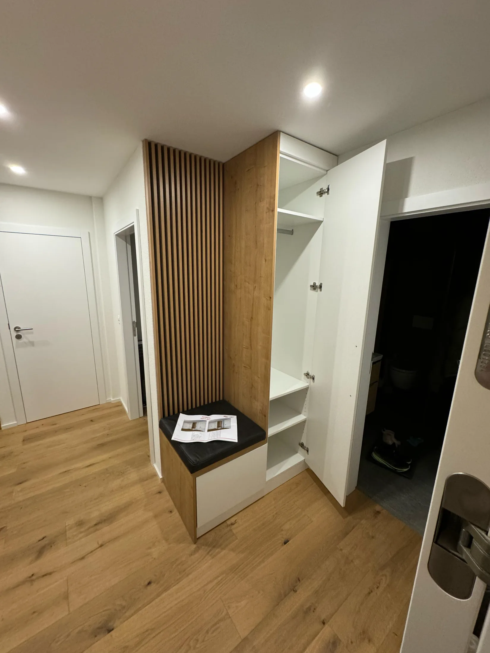 Eingangsbereich mit Garderobenschrank, Sitzbank und Holzlamellen-Wand