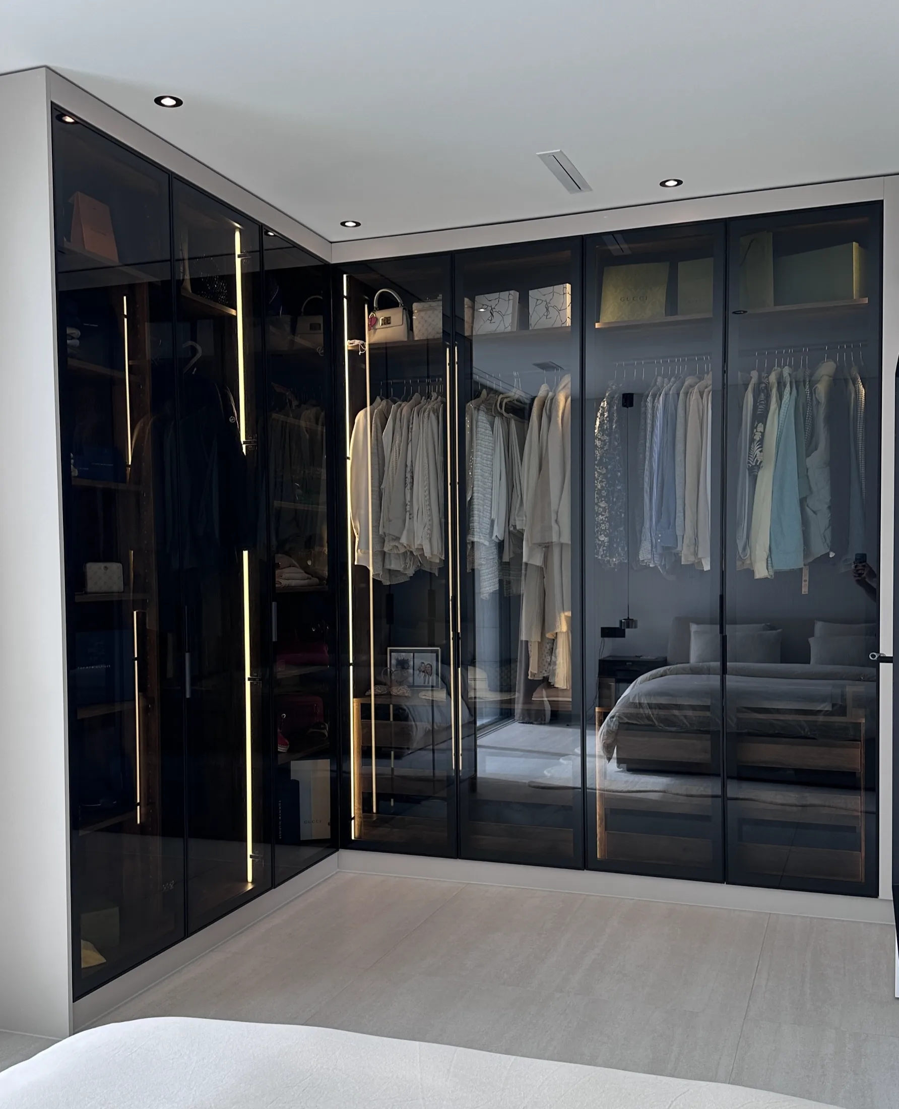 Moderner Eck-Kleiderschrank mit Rauchglasfront und LED-Beleuchtung im Schlafzimmer