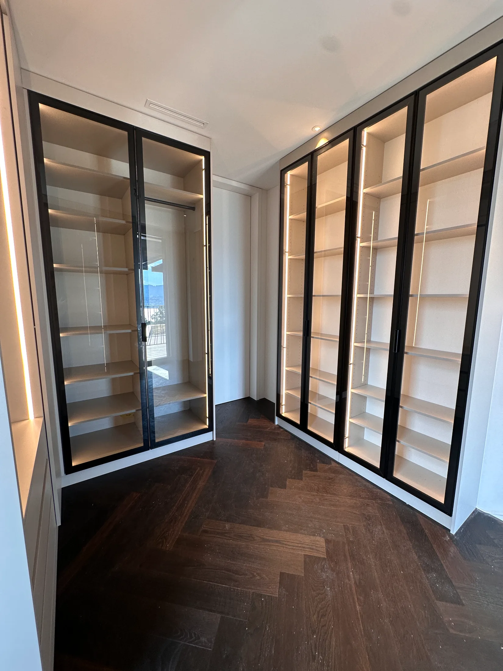 Eleganter Glasschrank mit schwarzen Glasrahmen, LED-Beleuchtung und offenen Innenfächern